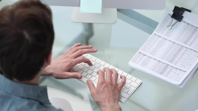 a businessman analyzes documents and charts and works on a laptop with a calculator. remote image