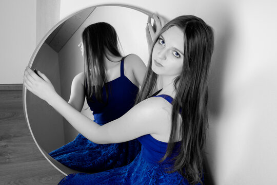 young woman looks in the mirror - art photo