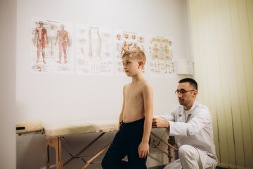Orthopedist examining child's back in clinic. Scoliosis treatment - obrazy, fototapety, plakaty