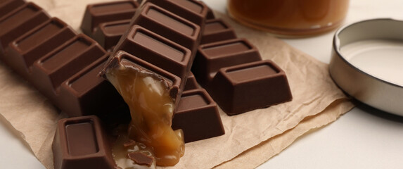 Tasty sweet chocolate candy bars on white table. Banner design