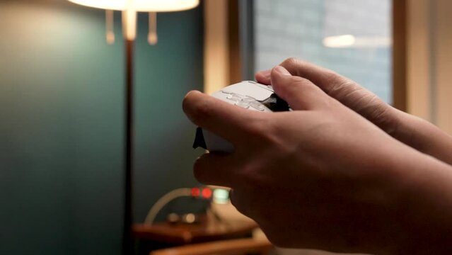 Hands of a young adult playing video games
