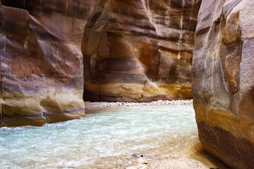Jordan. Wadi Al Mujib Canyon in Wadi Mujib Nature Biosphere Reserve. Sheer cliffs of enormous height are polished by water ofWadi Mujib River, also known as Arnon Stream, flowing along bottom of gorge