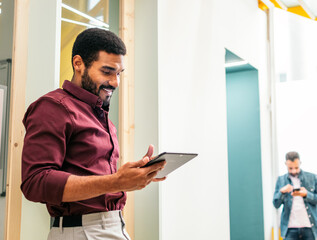 Fototapeta premium Smiling man in shirt working with a tablet in a coworking