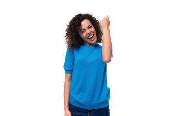 Fototapeta premium young curly woman in a blue sweater is experiencing happiness
