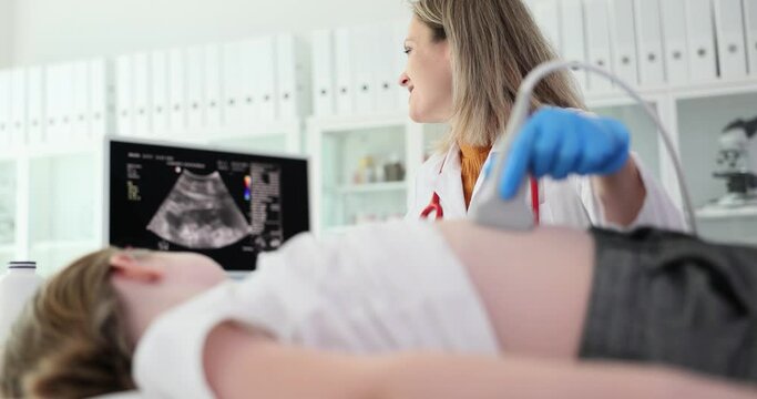 Doctor conducting ultrasound examination of internal organs of child in clinic. Diagnosis and treatment of diseases of liver and biliary tract in children