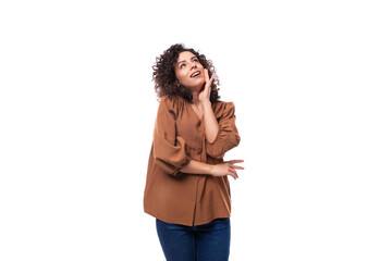 portrait of a young joyful brunette woman with curly hair dressed in a brown shirt