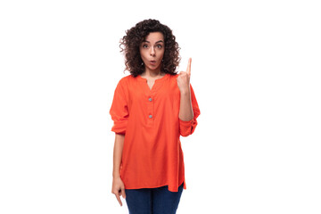 young curly brunette woman dressed in an orange blouse is inspired by an idea. brainstorming concept