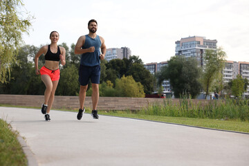 Healthy lifestyle. Happy couple running outdoors, space for text