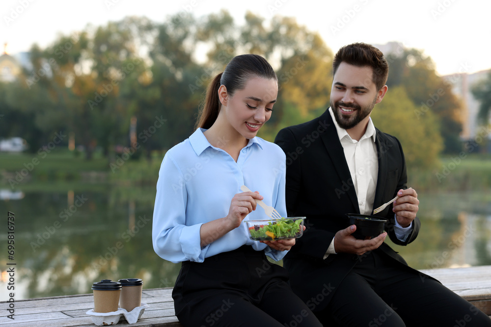 Poster Smiling business people spending time together during lunch outdoors