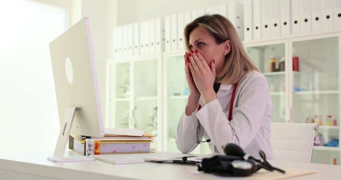 Unhappy crazy female doctor using computer in hospital confusing operating problem or device spam. Shocked doctor looking at computer screen