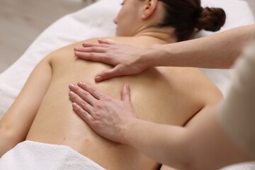 Fototapeta na wymiar Woman receiving back massage on couch in spa salon, closeup