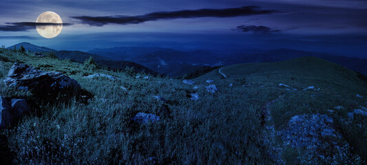 panoramic landscape with narrow path through meadow among stones on hillside at night. wonderful...