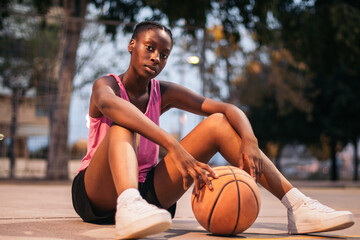 Confident female basketball player on the court - obrazy, fototapety, plakaty