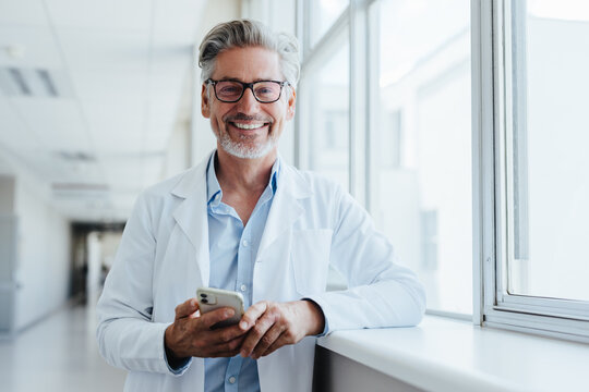 Portrait of a senior doctor holding a smartphone in a hospital