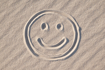 Happy smiley drawn on wavy sand, close up. Concept of good emotions, positive mood, cheer and...