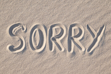 Word Sorry written on sand, close up. Concept of apologising and sorrowful mood