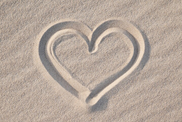 Shape of heart drawn on the sand, close up. Concept of love, passionate feelings, positive...