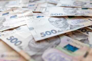 Banknotes of 500 hryvnias value scattered on the table, close up. Concept of earnings, wealth,...