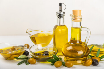 Olive oil in a bottle on a white texture background. Oil bottle with branches and fruits of olives. Place for text. copy space. cooking oil and salad dressing.