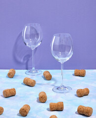 Two wine or champagne glasses and a lots of bottles corks scattered on the table. Dinner for two.