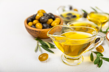 Olive oil in a bottle on a white texture background. Oil bottle with branches and fruits of olives. Place for text. copy space. cooking oil and salad dressing.