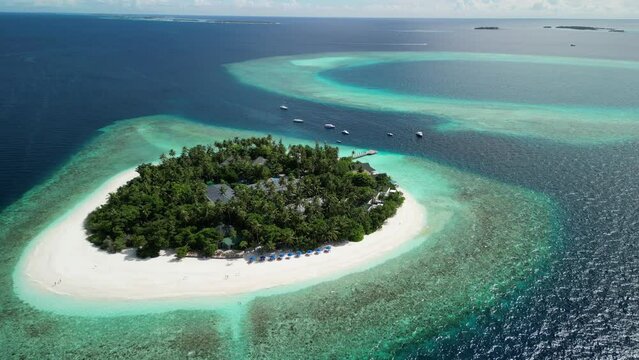 Tropical Island Paradise - Malahini Kuda Bandos, Maldives: Aerial drone anticlockwise rotate and pull out, neighbouring reef backdrop