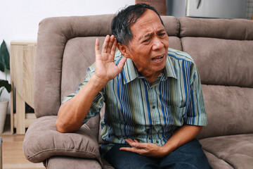 Portrait of senior Asian man having hearing problems