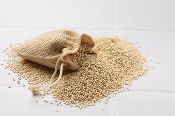 Dry quinoa seeds in bag on white tiled table