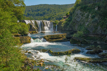 Fototapeta na wymiar Strbacki Buk, a terraced waterfall on the Una River on the border between the Federation of Bosnia and Herzegovina and Croatia. Early September