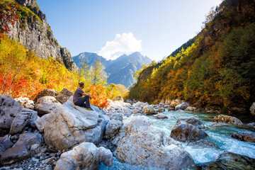 Man Sitting on a Rock Near a River in the Colorful Albanian Alps 