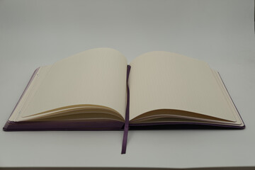 Purple open notebook on a white background