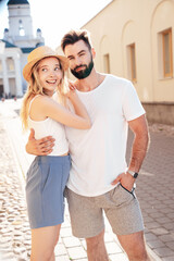 Naklejka premium Smiling beautiful woman and her handsome boyfriend. Woman in casual summer clothes. Happy cheerful family. Female having fun. Couple posing in street at sunny day. Having tender moments. In hat