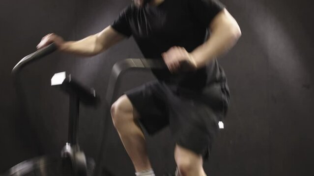 Athlete in the gym doing cycling in the gym, training for sports motivation and cardio exercises for a strong body. A man's face with testosterone gets better and moves for well-being and health