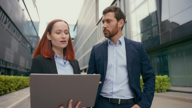 Caucasian business man boss reprimanding female employee worker woman showing online mistake bad work result company leader dissatisfied with laptop data talking scolding computer failure in city