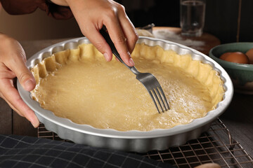 Woman making quiche at wooden table, closeup