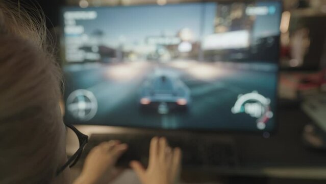 Isolated caucasian gamer girl sitting in front of a blurred computer screen playing games, focus on players head with screen in bokeh