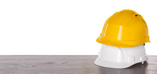 Hard hats on wooden table against white background. Safety equipment