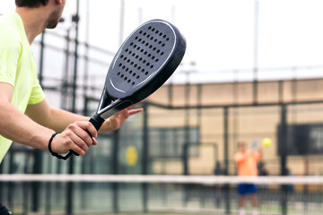 back view of a man playing paddle tennis - obrazy, fototapety, plakaty