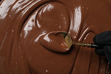 Person making tasty milk chocolate paste, top view