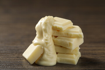 Pieces of white chocolate and tasty paste on wooden table, closeup