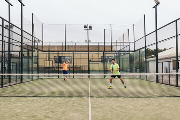 two young man playing paddle tennis