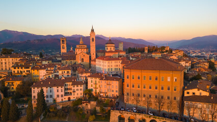 Fototapeta na wymiar Bergamo, Italy. Scenic aerial view of the old town city center Citta Alta. Landscape of the historical buildings during the sunset