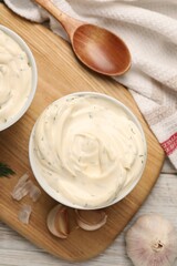 Tasty sauce with garlic and spoon on table, top view