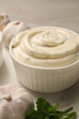 Tasty sauce with garlic and parsley on table, closeup