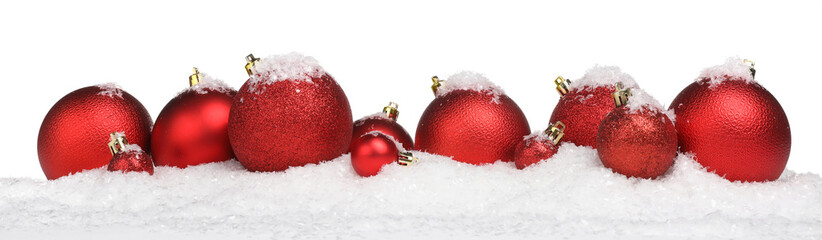 Beautiful red Christmas balls on snow against white background