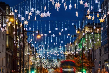 Fototapeten Festive Christmas decorations in the streets of London with red bus traffic during night time © moofushi
