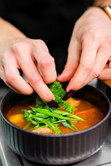 Professional chef cooking Shurpa soup with lamb meat in restaurant kitchen
