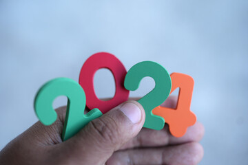 Happy New Year 2024 concept, wooden numbers 2024 in human hand