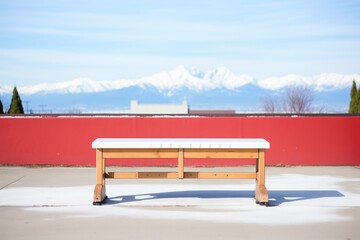 Obraz premium single bench with snow capped mountains backdrop