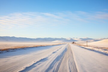 Fototapeta na wymiar snowdrifts flanking an untouched gravel road with distant hills